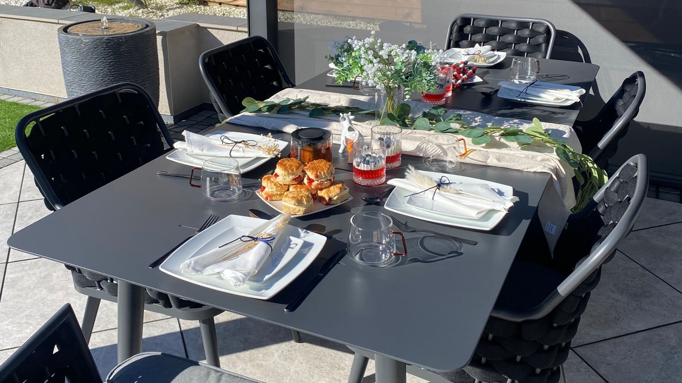 Outdoor dining set with tableware and decorations.