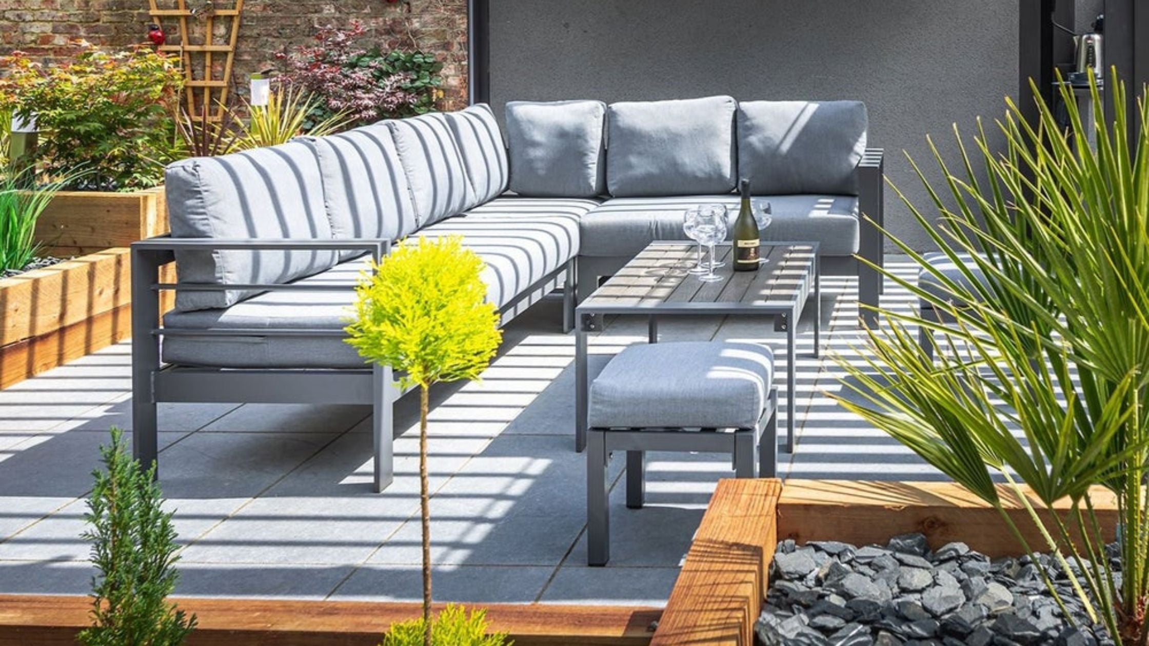 Grey aluminium corner sofa set with a matching coffee table and two stools,