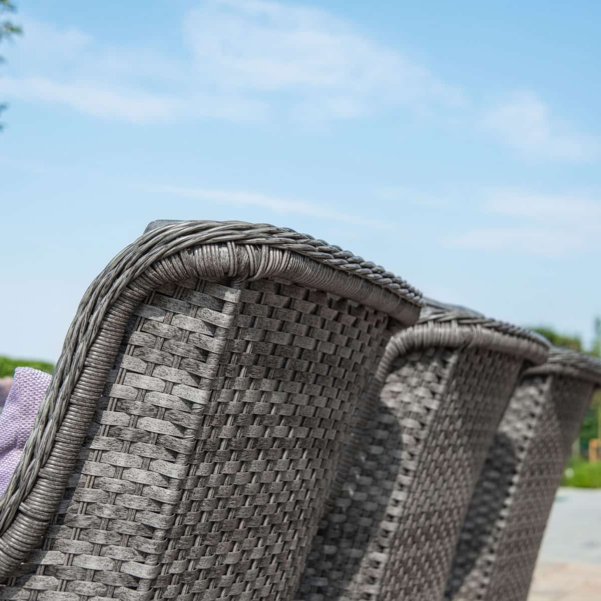 Close up of a grey rattan high back dining chair