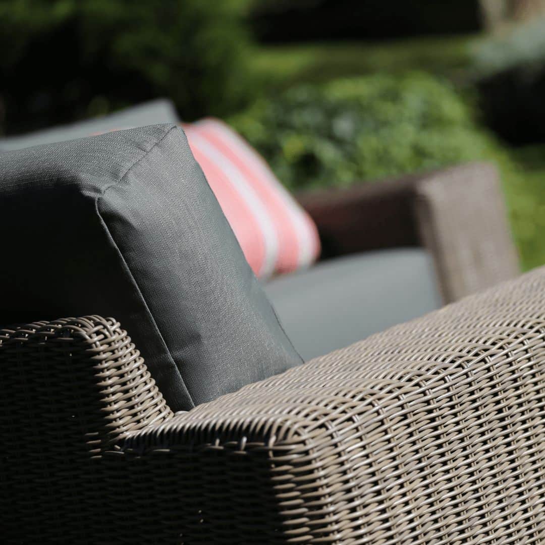 Close up of a beige rattan corner sofa arm.