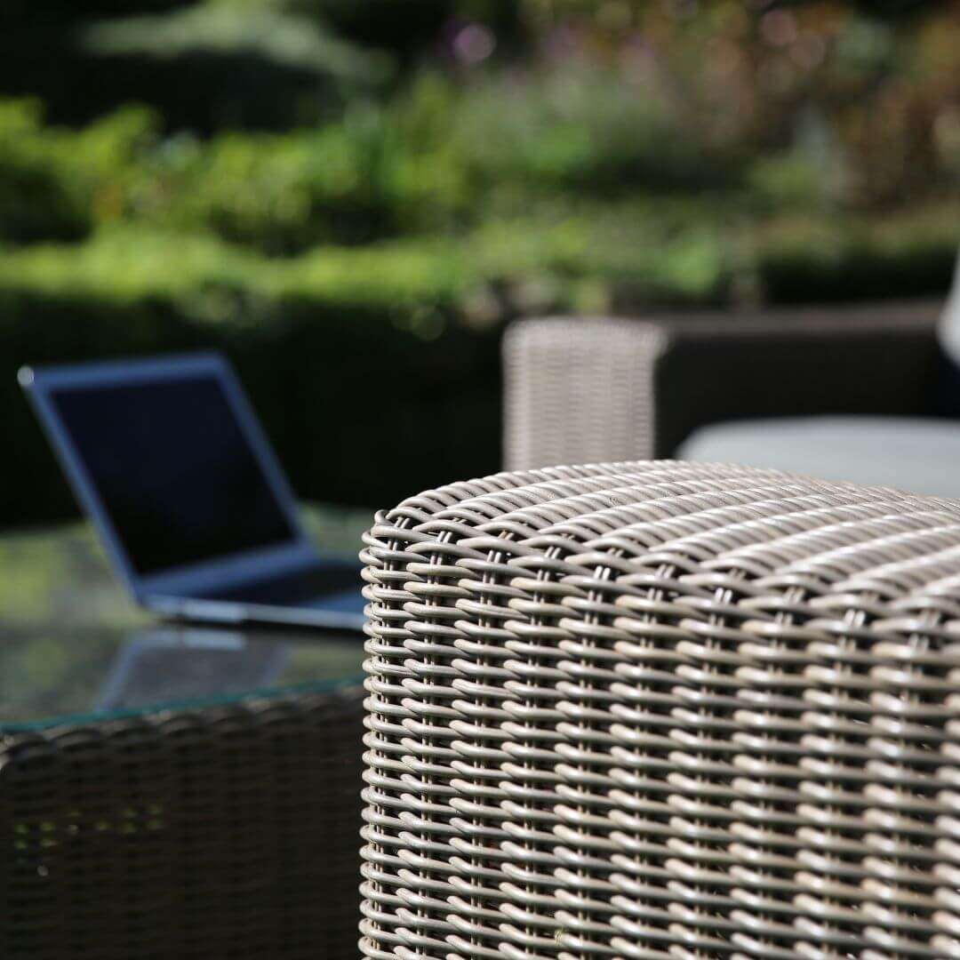 Close up of a beige rattan corner sofa arm.