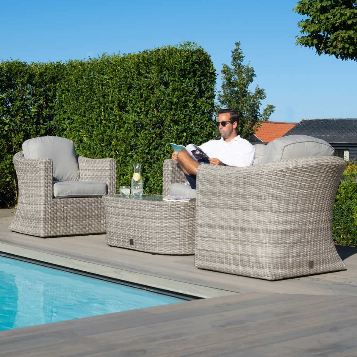 Light grey rattan 2 seat sofa set with two armchairs and a matching oval coffee table