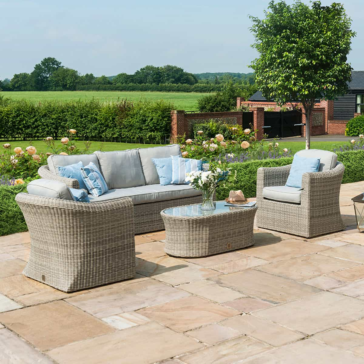 Light grey rattan 3 seat sofa set with two armchairs and a matching oval coffee table