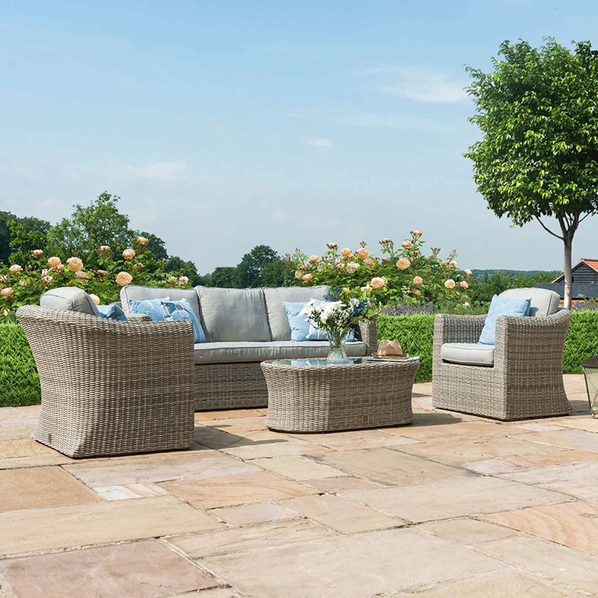 Light grey rattan 3 seat sofa set with two armchairs and a matching oval coffee table