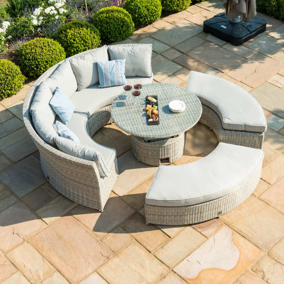 Light grey rattan lifestyle suite with a curved sofa, curved bench and a rising table