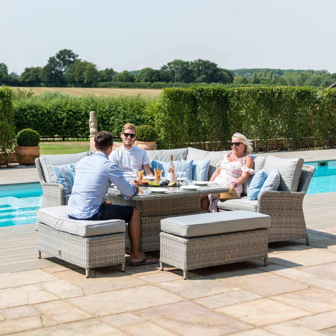 Light grey rattan corner sofa dining set with a square ice bucket rising table and two benches