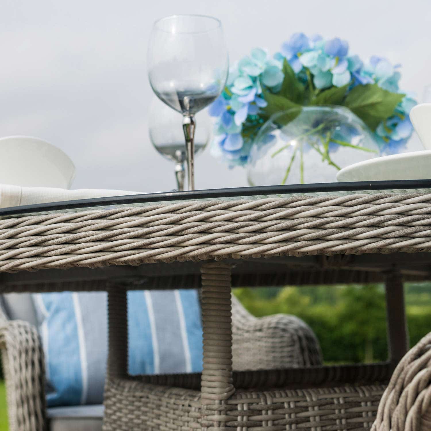 Close up of a light grey rattan round dining table