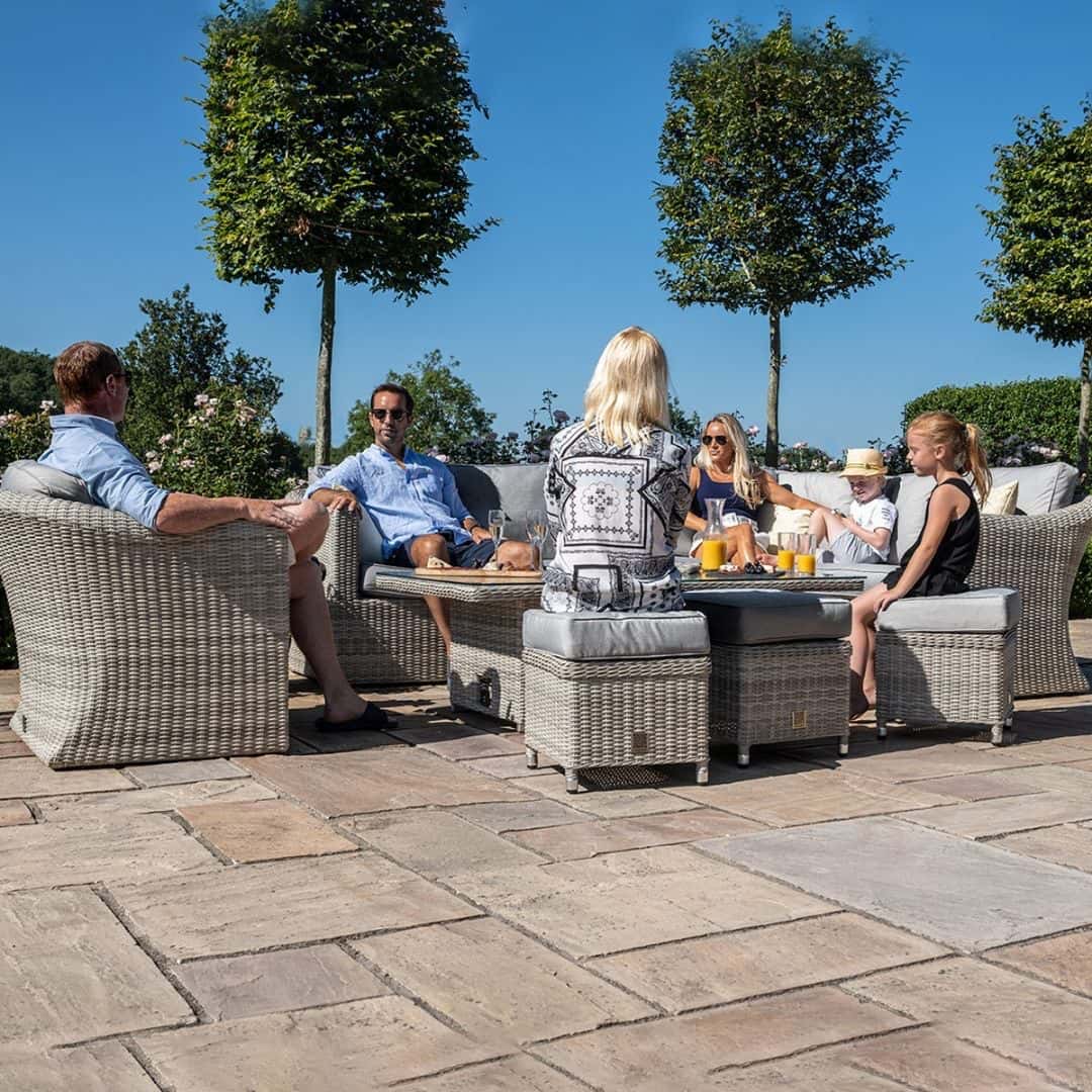 Light grey rattan corner sofa dining set with an armchair, three stools and a rectangular ice bucket rising table