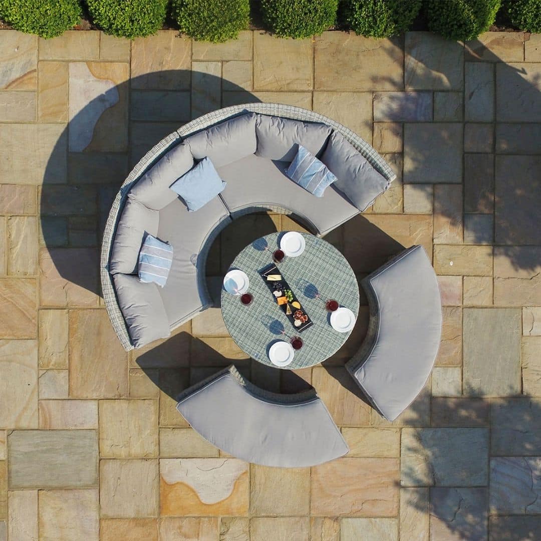 Overhead view of a light grey rattan lifestyle suite with a curved sofa, curved bench and a rising table
