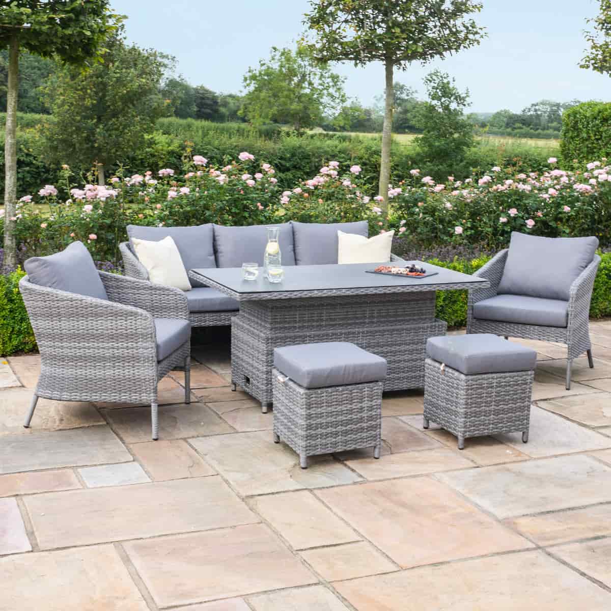 Grey rattan casual sofa dining set with rectangular rising table, two chairs and two stools