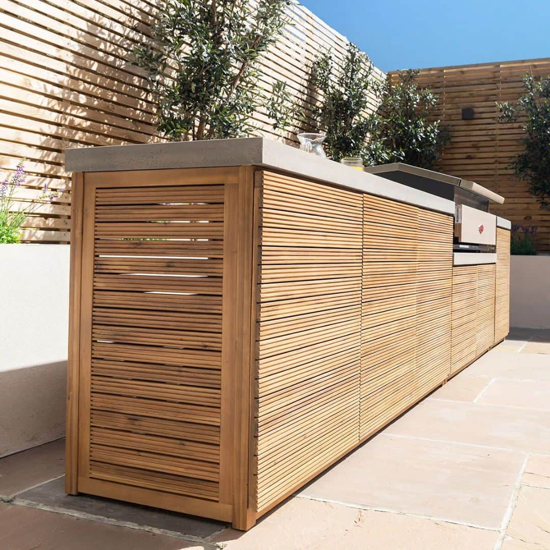 Acacia wood and a composite concrete worktop outdoor kitchen unit with bbq grill.