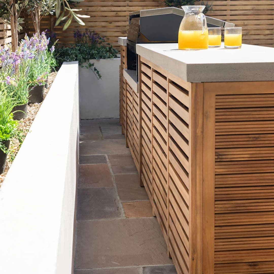Acacia wood and a composite concrete worktop outdoor kitchen unit with bbq grill.