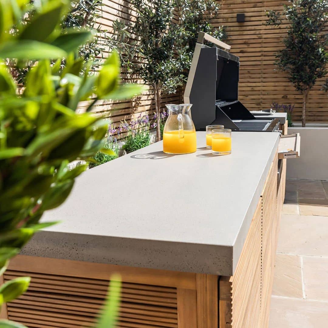 Acacia wood and a composite concrete worktop outdoor kitchen unit with bbq grill.