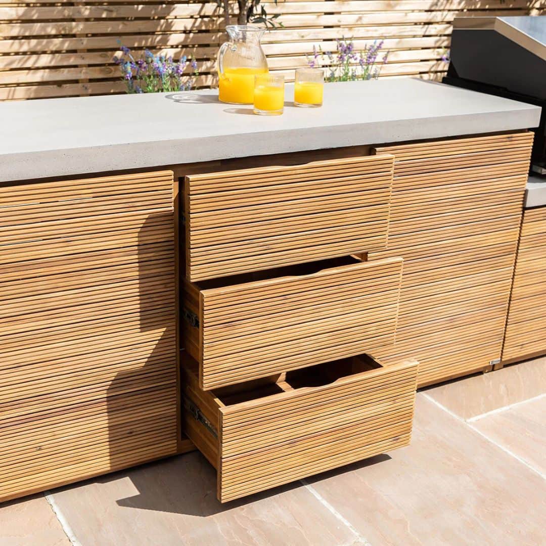 Acacia wood and a composite concrete worktop outdoor kitchen unit with bbq grill.