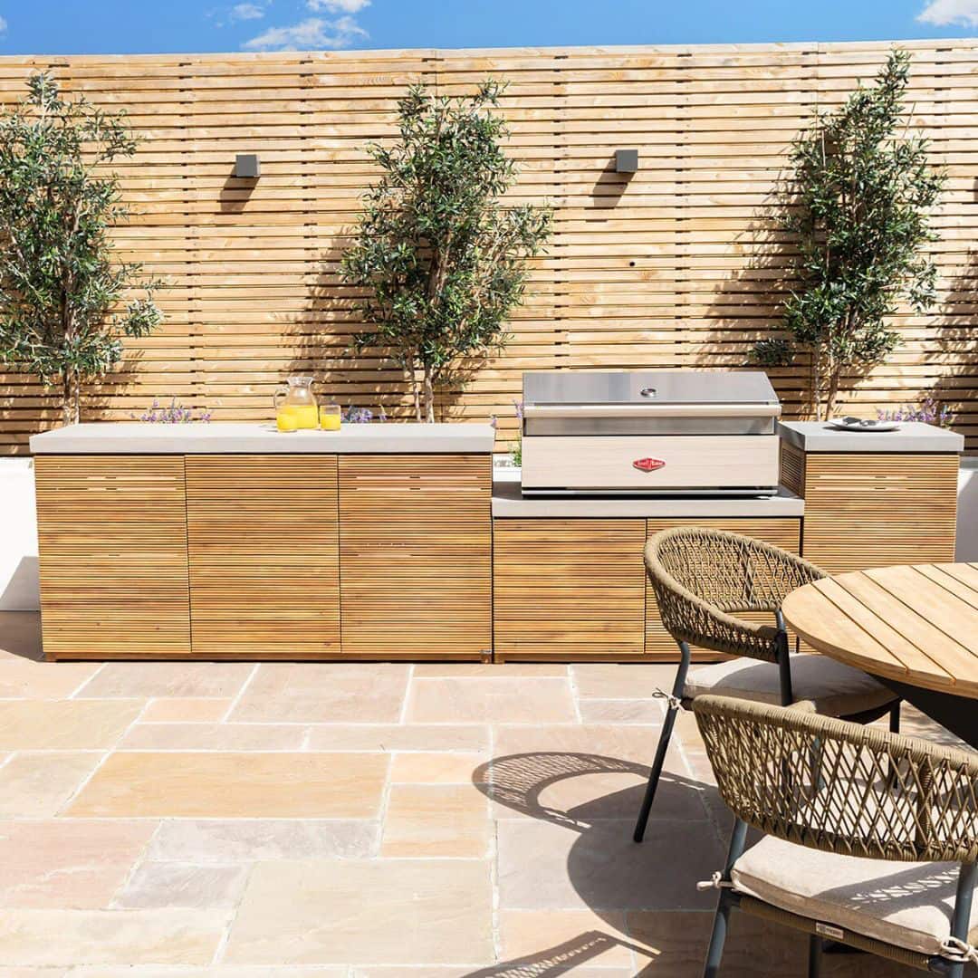 Acacia wood and a composite concrete worktop outdoor kitchen unit with bbq grill.