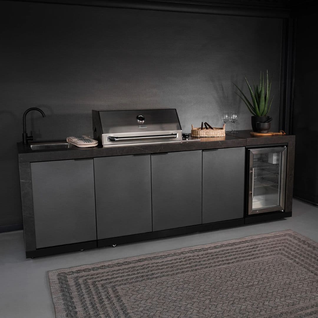 Grey outdoor kitchen unit with a bbq top unit, sink and fridge.