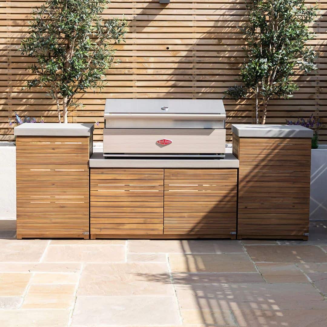Acacia wood and a composite concrete worktop outdoor kitchen unit with bbq grill.