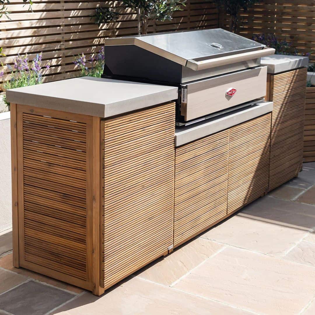 Acacia wood and a composite concrete worktop outdoor kitchen unit with bbq grill.