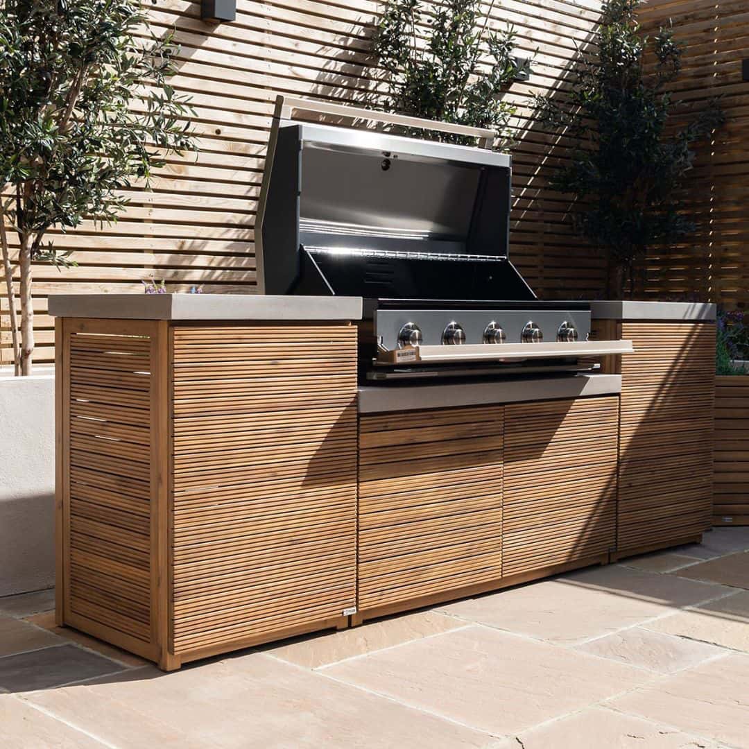 Acacia wood and a composite concrete worktop outdoor kitchen unit with bbq grill.