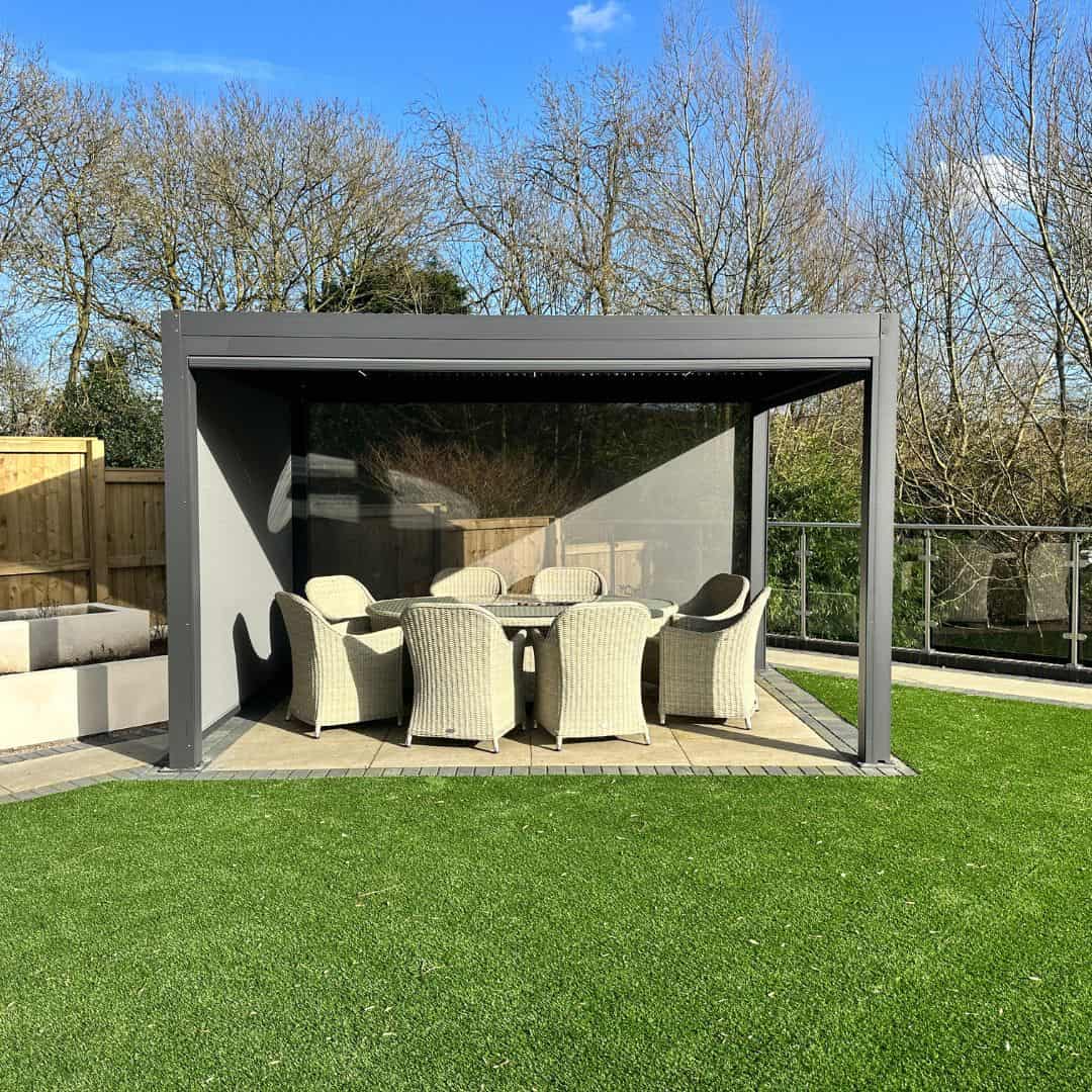 Anthracite grey aluminium pergola with 4 motorised zip screw and motorised louvred roof with LED lighting.