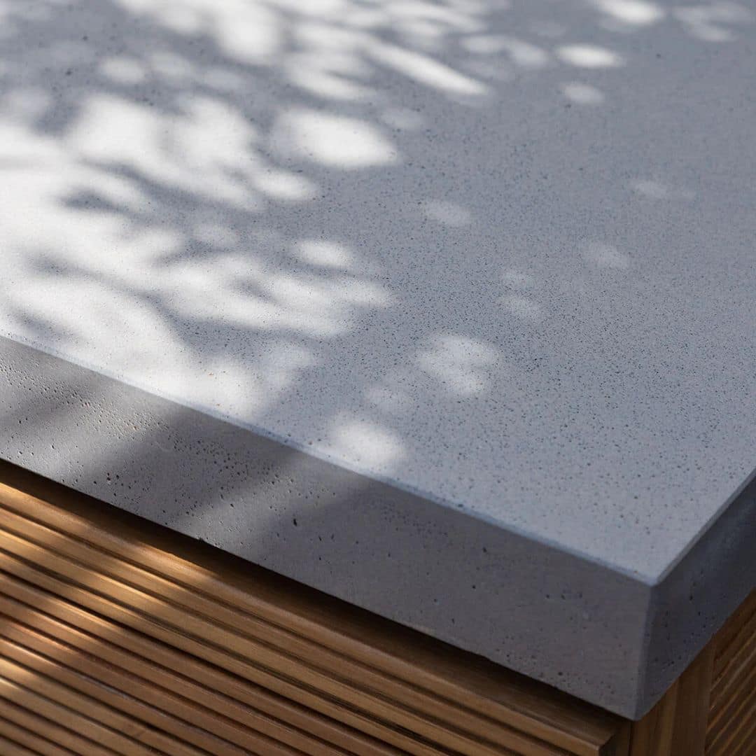 Acacia wood and a composite concrete worktop outdoor kitchen unit with bbq grill.