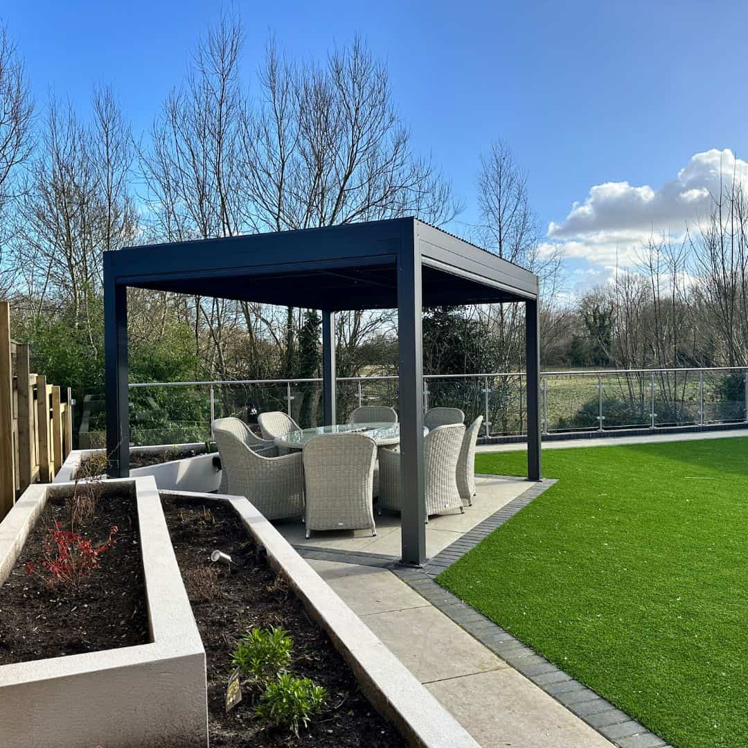 Anthracite grey aluminium pergola with 4 motorised zip screw and motorised louvred roof with LED lighting.