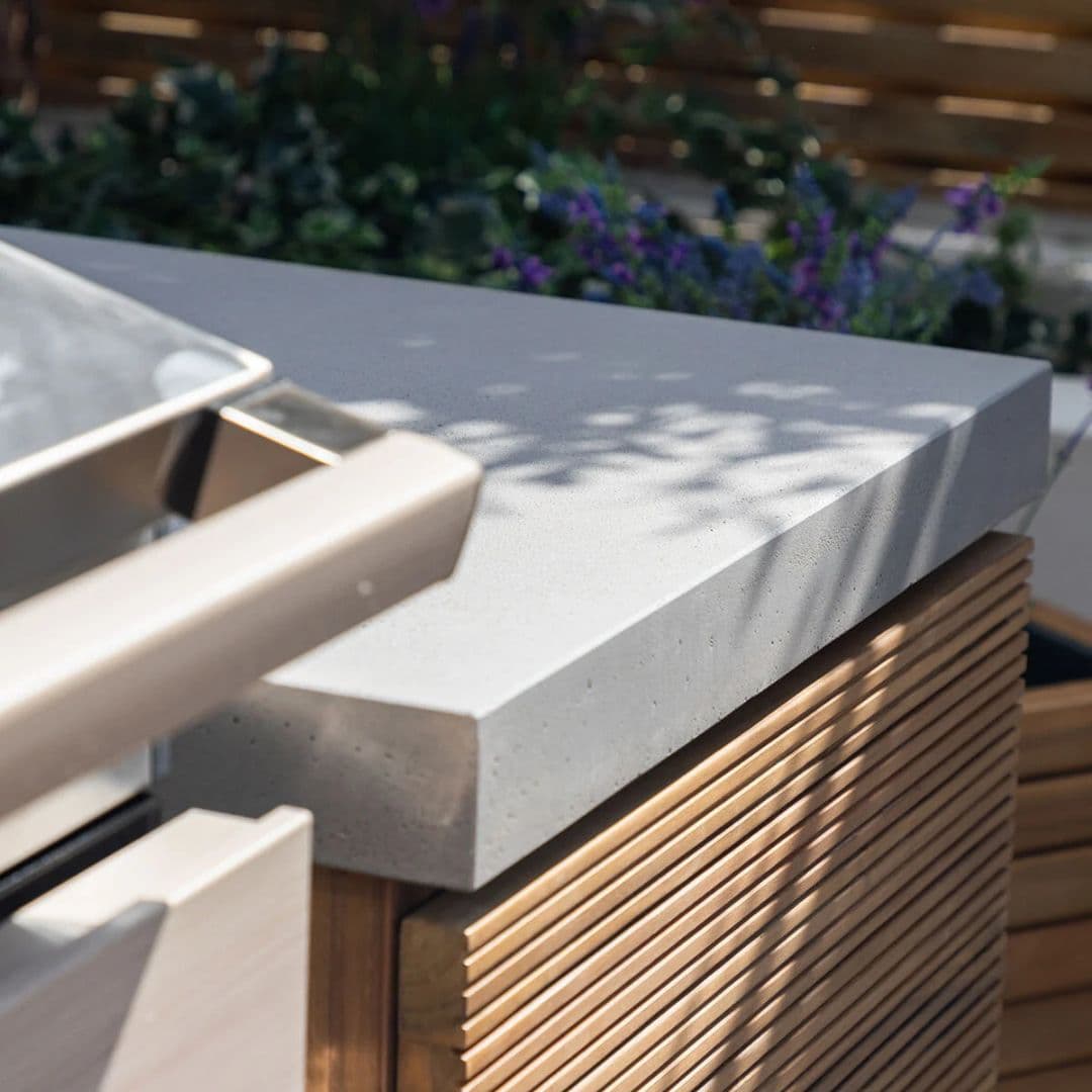 Acacia wood and a composite concrete worktop outdoor kitchen unit with bbq grill.