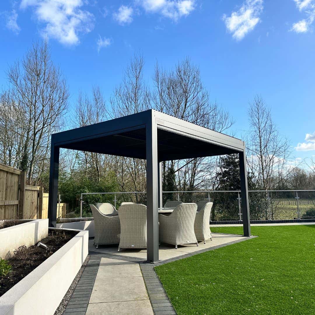 Anthracite grey aluminium pergola with 4 motorised zip screw and motorised louvred roof with LED lighting.
