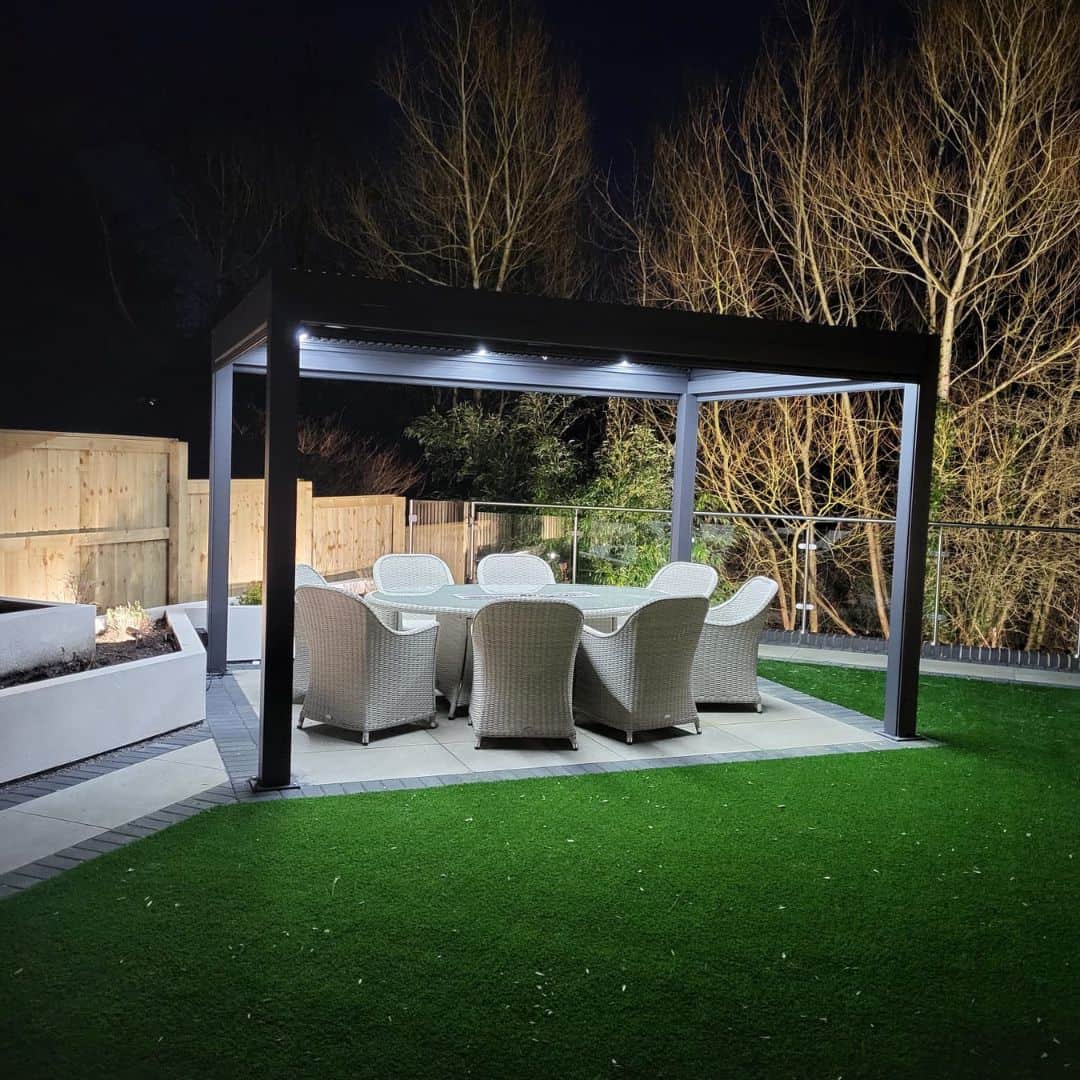 Anthracite grey aluminium pergola with 4 motorised zip screw and motorised louvred roof with LED lighting.