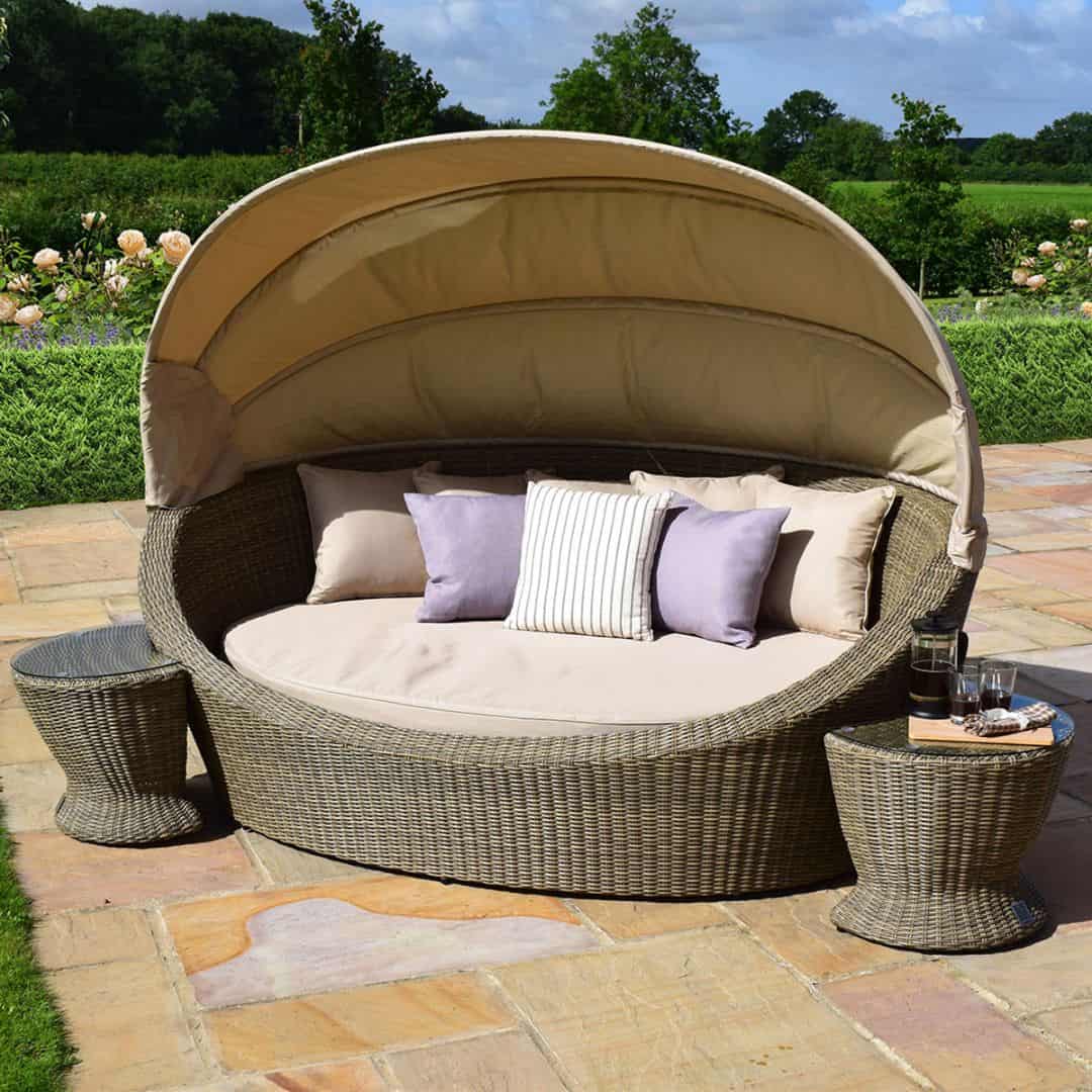 Natural coloured rattan daybed with retractable canvas hood and two matching side tables