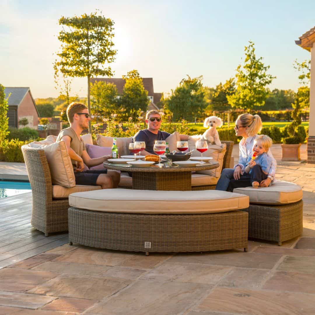 Natural coloured rattan curved casual dining set with two benches and a rising table.