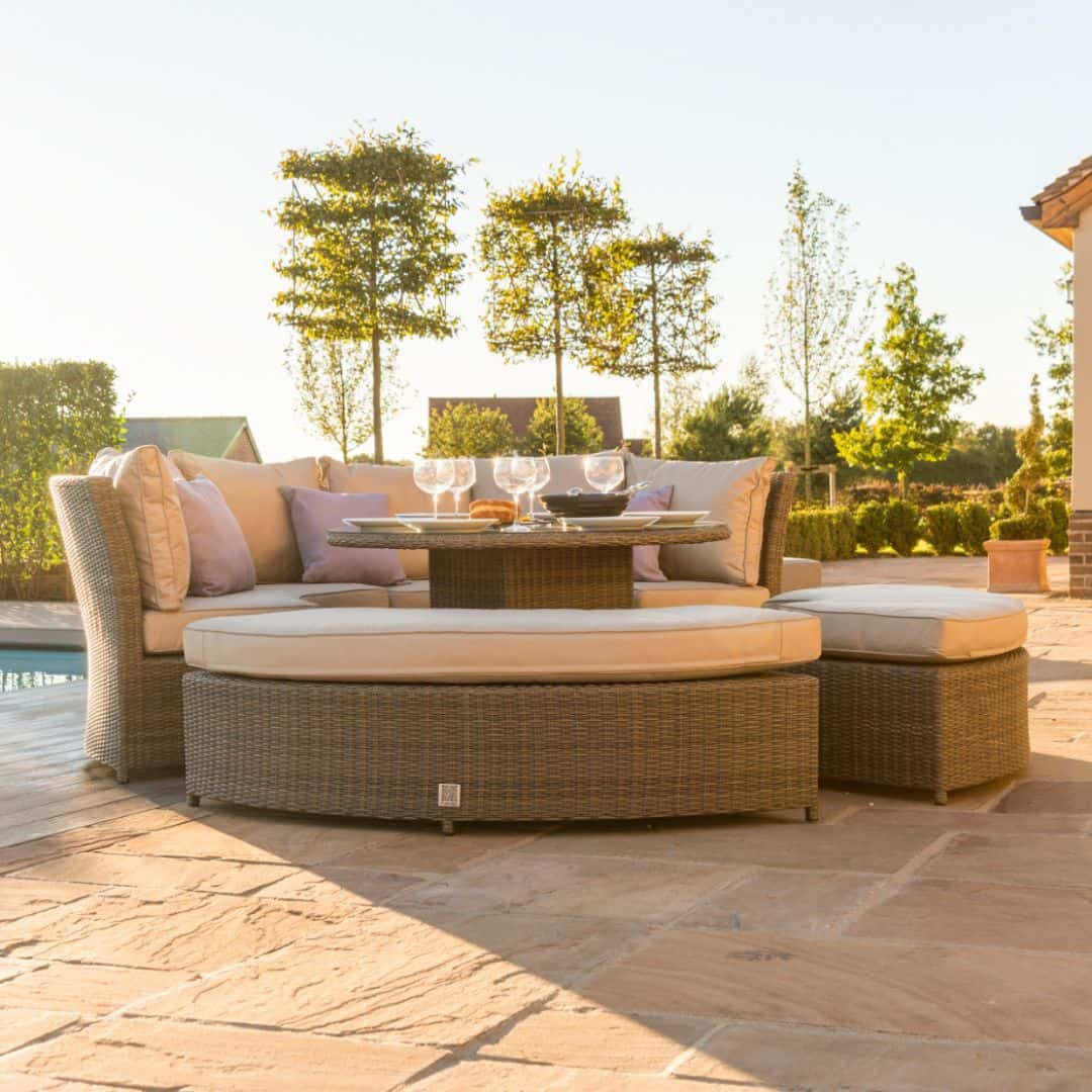 Natural coloured rattan curved casual dining set with two benches and a rising table.