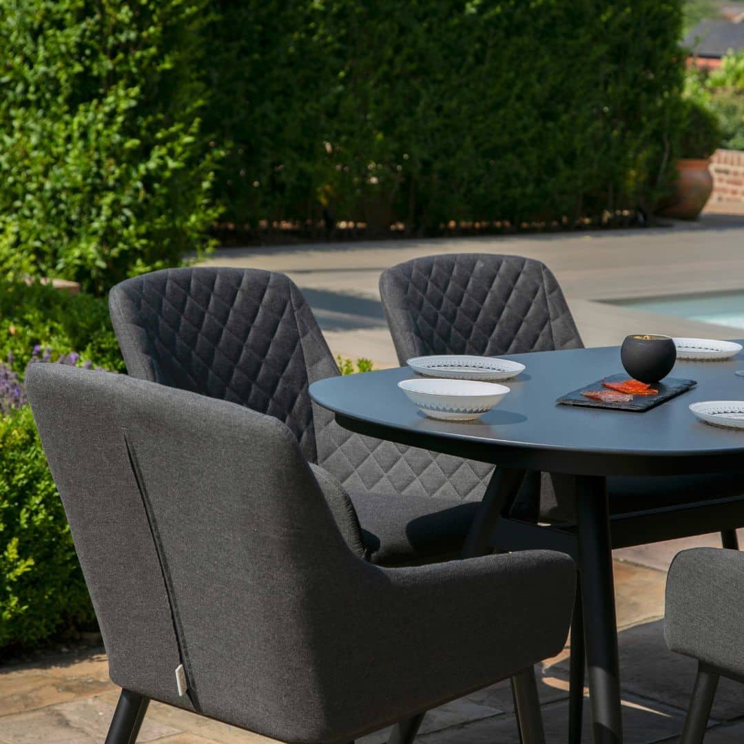 Close up of a charcoal fabric dining chair and oval dining table #colour_charcoal