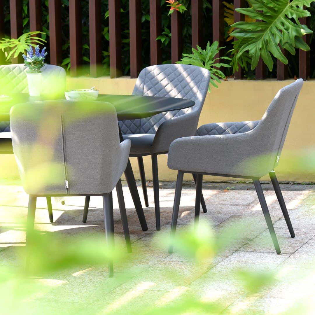 Close up of a grey fabric dining chair and oval dining table #colour_flanelle