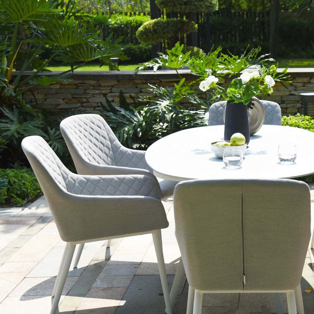 Close up of a light grey fabric chair and white oval dining table #colour_lead chine