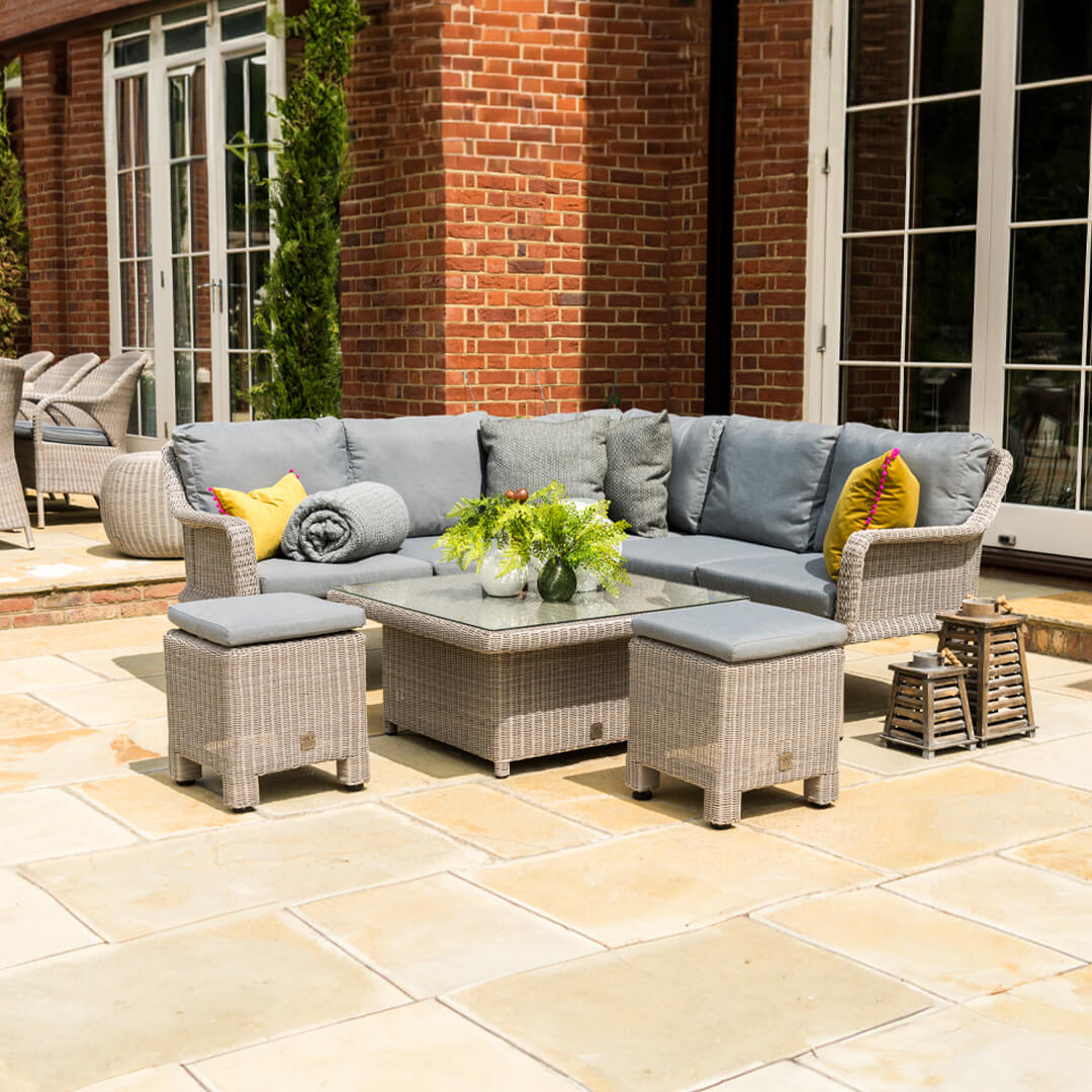 Wicker rattan casual dining set with corner sofa, two stools and a square rising table.