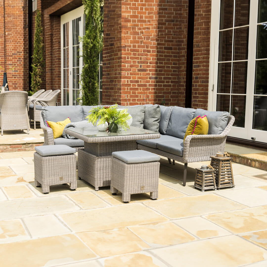 Wicker rattan casual dining set with corner sofa, two stools and a square rising table.