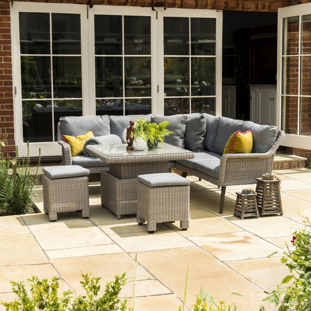 Wicker rattan casual dining set with corner sofa, two stools and a square rising table.