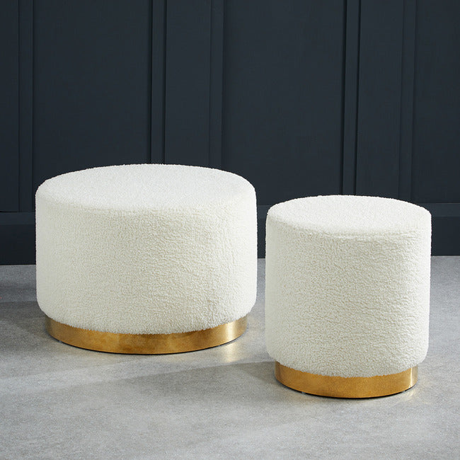 White boucle footstool with gold effect circular frame.