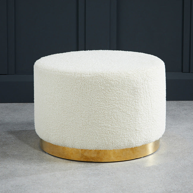White boucle footstool with gold effect circular frame.