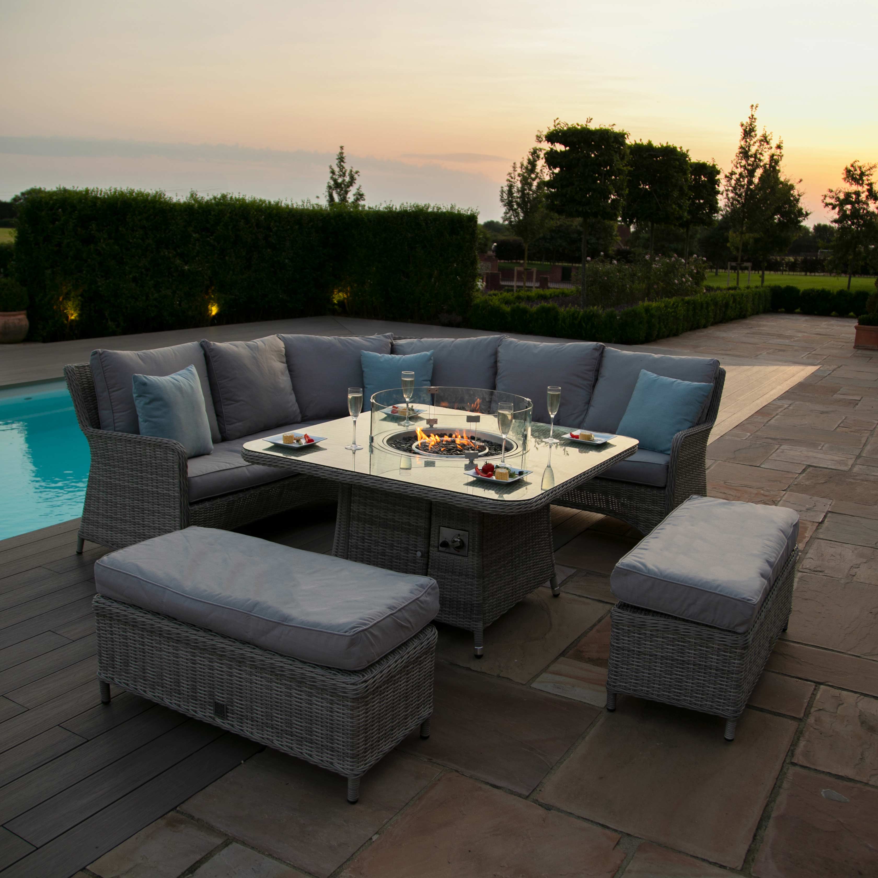Light grey coloured rattan corner sofa with two matching benches and square fire pit table.