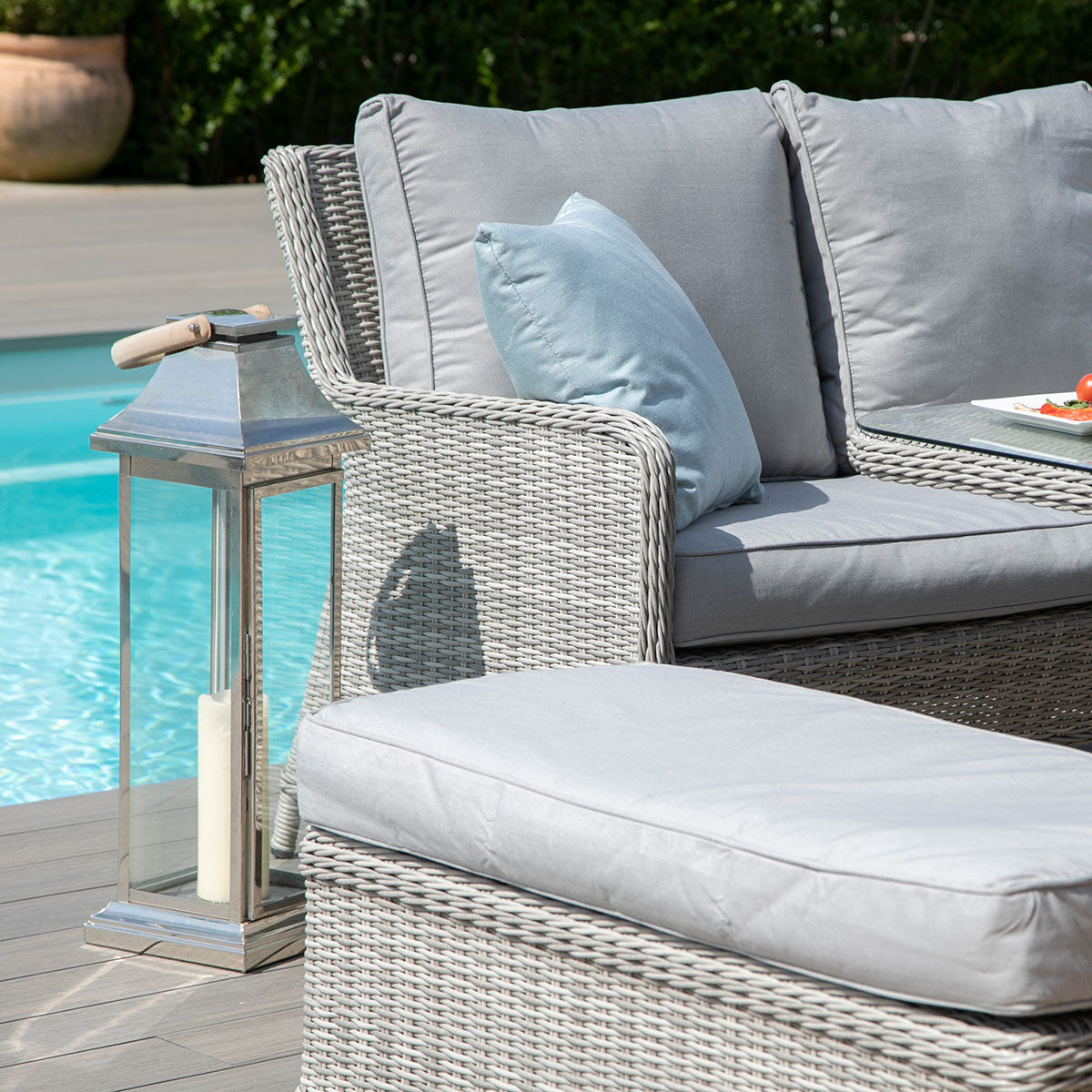 Light grey coloured rattan corner sofa with two matching benches and square fire pit table.