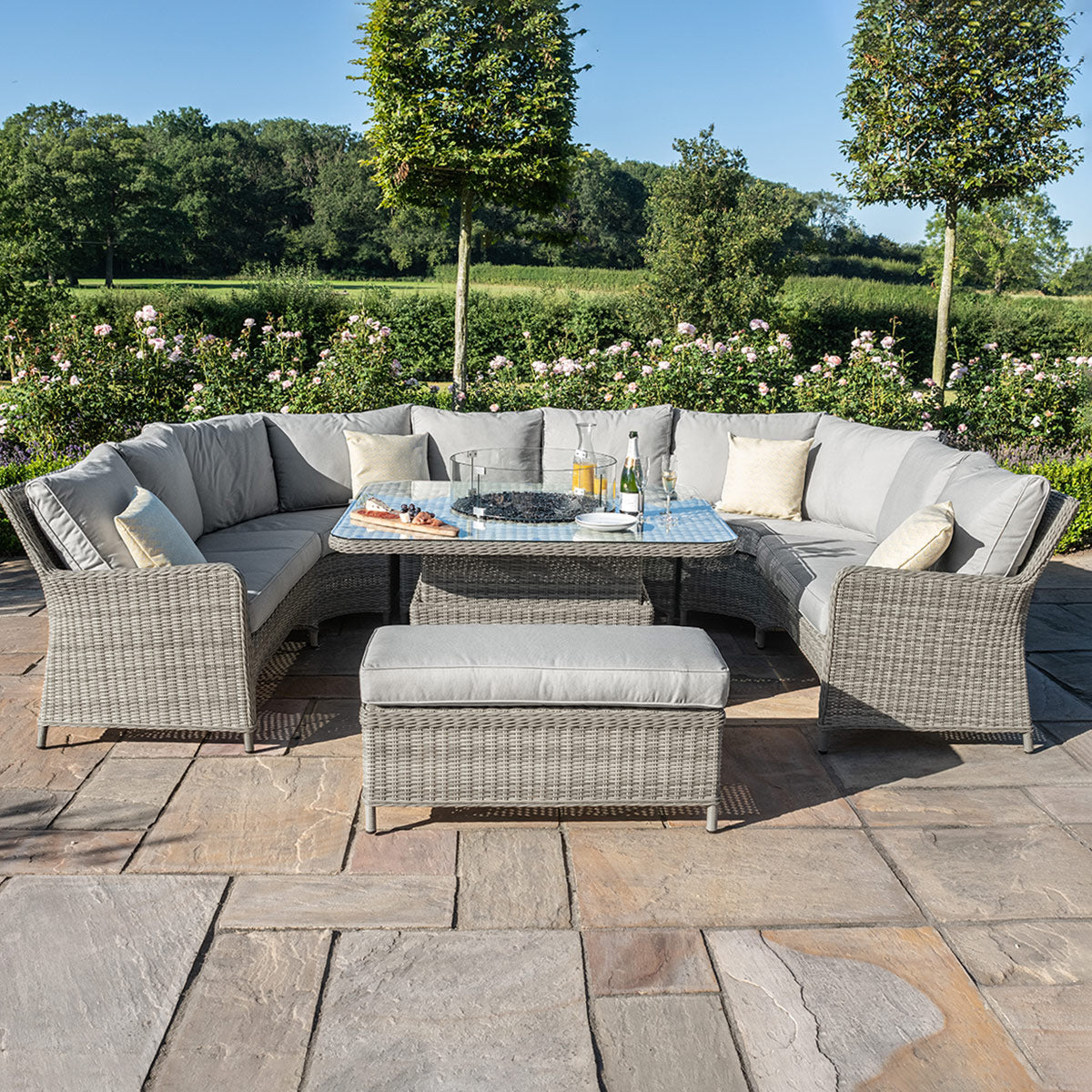 Light grey coloured rattan u shape sofa with matching bench and square fire pit table.