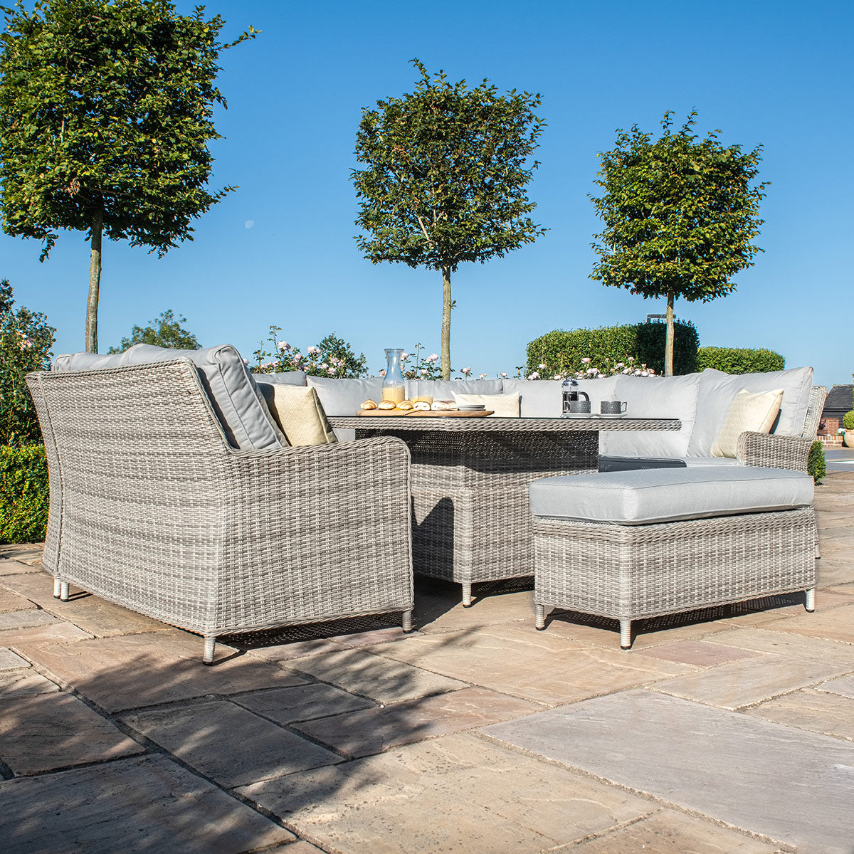Light grey coloured rattan u shape sofa with matching bench and square rising table.