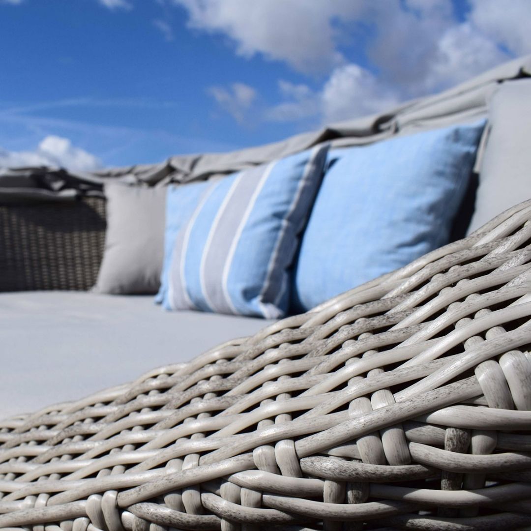 Light grey rattan daybed with retractable canvas hood and two matching side tables