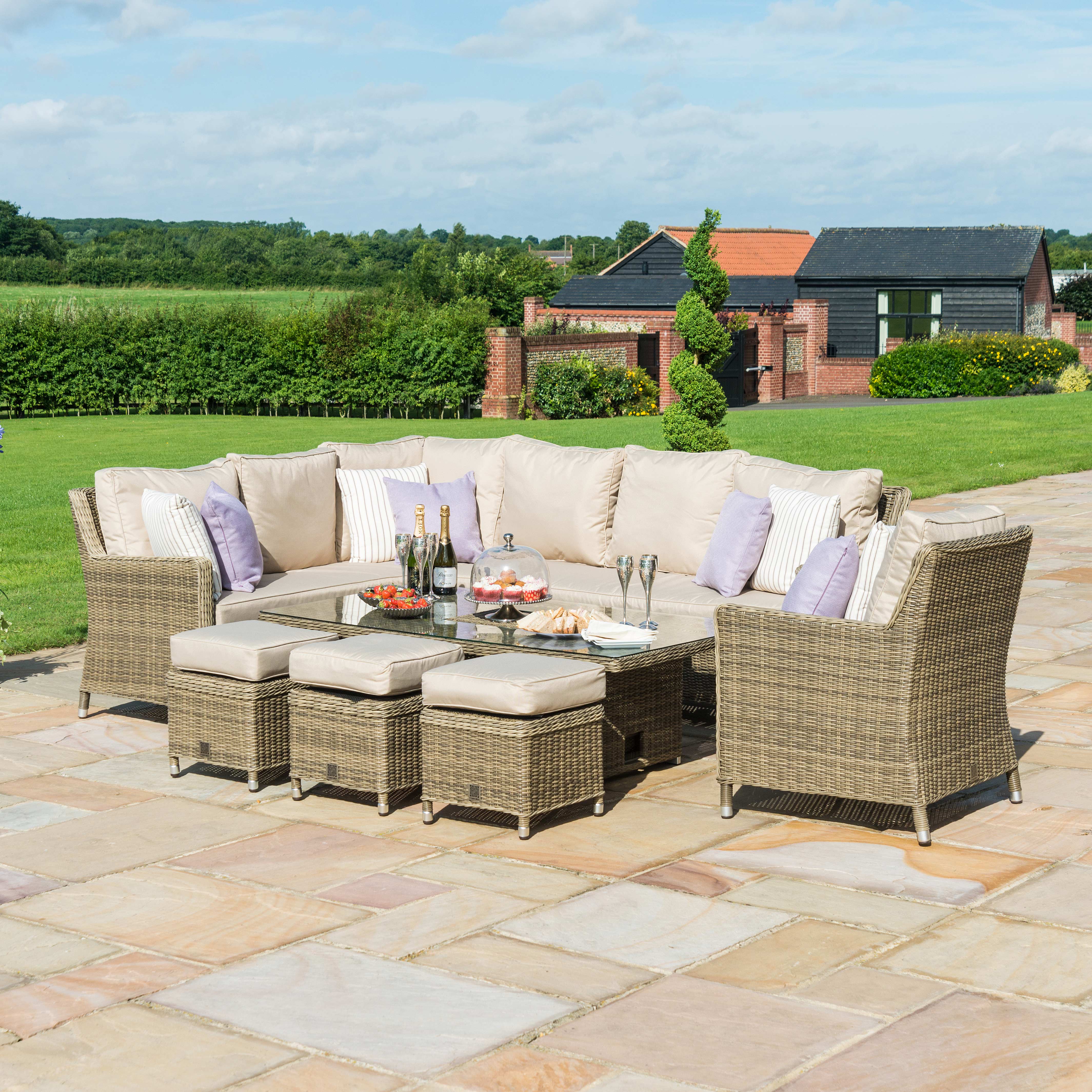 Natural coloured rattan corner sofa dining set with matching armchair, three stools and a rectangle rising table with ice bucket. Table is at a coffee table height.