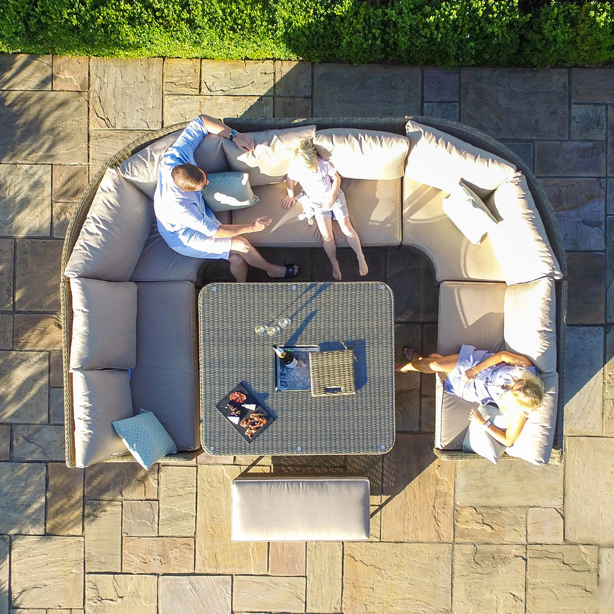 Overhead view of a natural coloured rattan u shaped sofa with matching bench and ice bucket rising table.