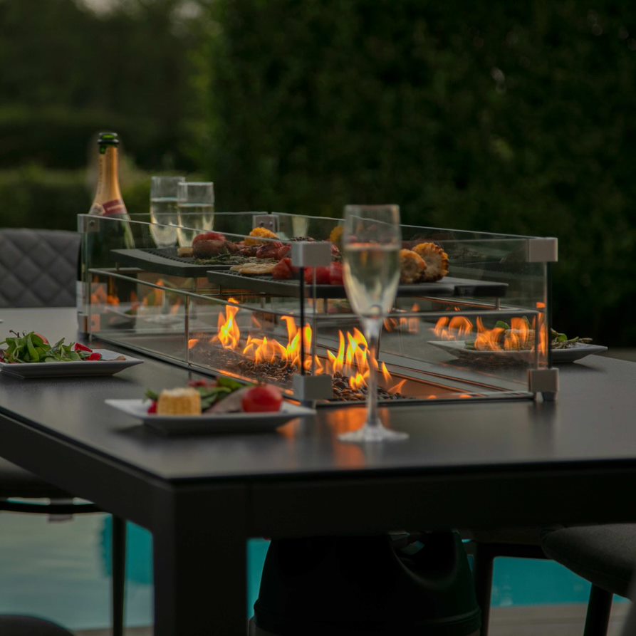 Close up of a fire pit dining table with fire pit turned on #colour_charcoal #colour_flanelle #colour_taupe
