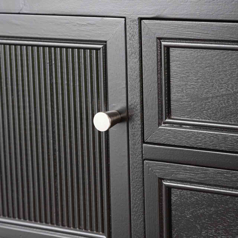 Close up of a black wood finish sideboard door with grooved design. 