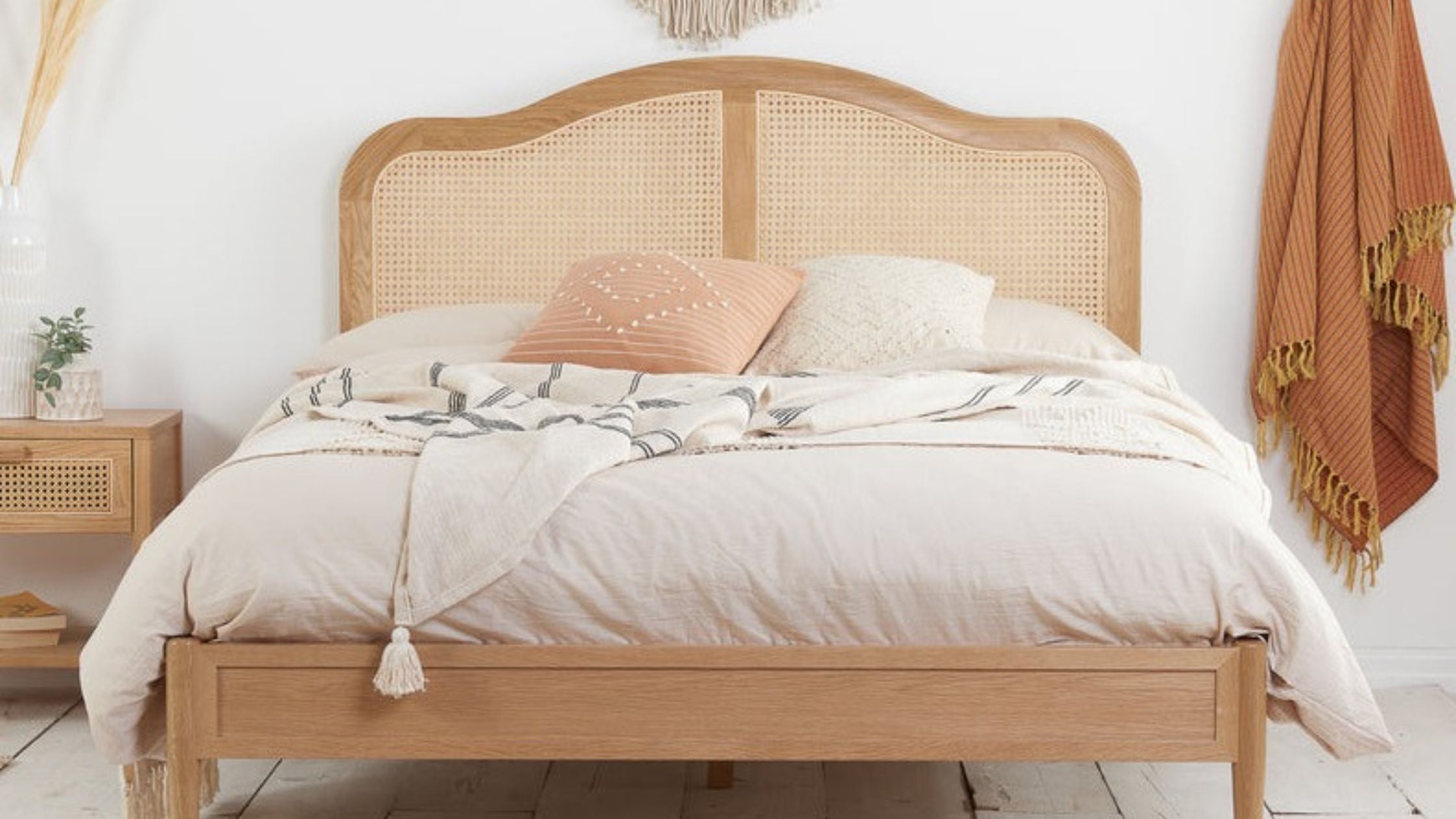 Front view of a weathered oak bed with rattan headboard. 
